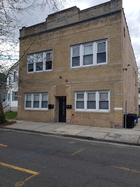 the front of a brick building with a black door