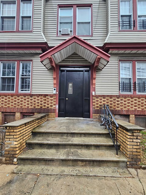 the front of a house with steps and a black door