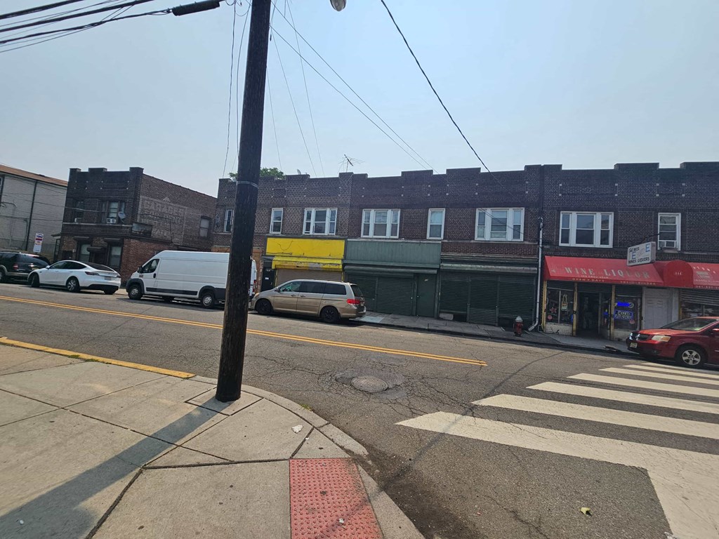 the corner of a city street with cars and a building