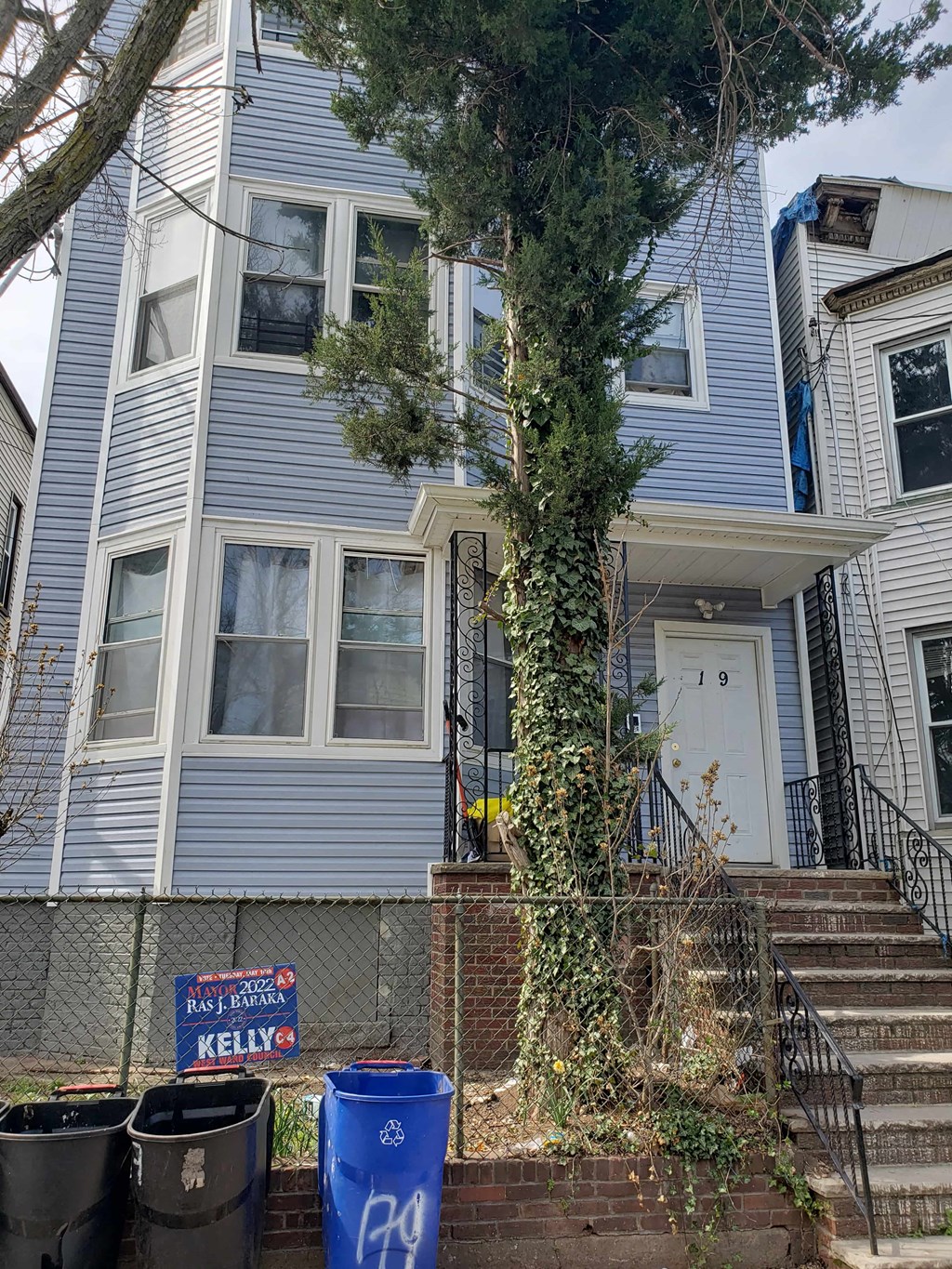A blue house with a white door and a sign that says Kelly.