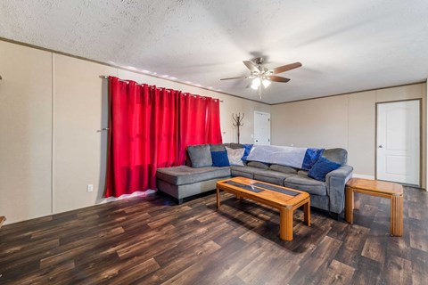 A living room with a grey couch and a wooden coffee table.