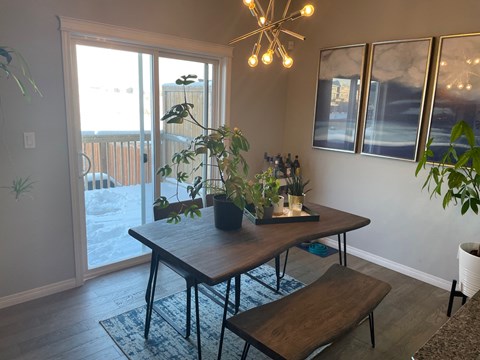 a dining room with a table and chairs and a sliding glass door