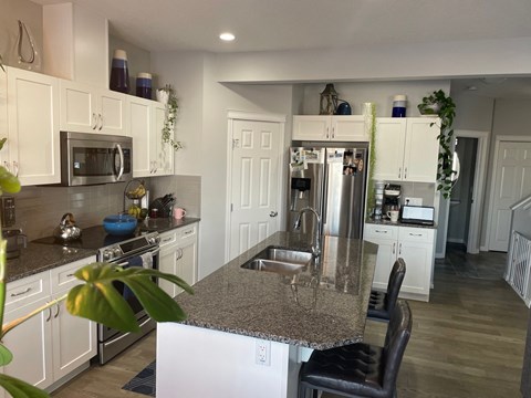 a kitchen with white cabinets and a granite counter top
