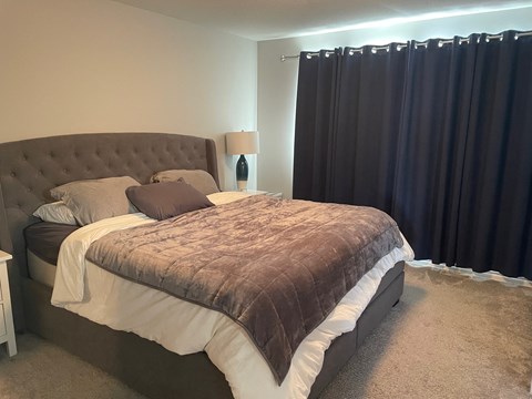 a bedroom with a bed and black curtains