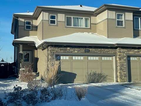 a house with a garage door in the snow