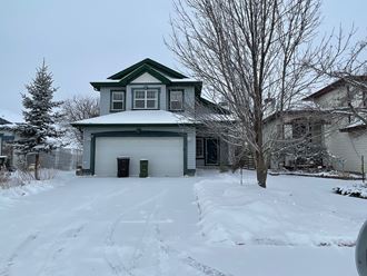a garage in the snow in front of a house