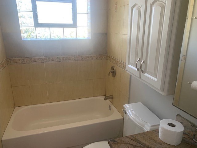 A white bathroom with a tub, toilet, and sink.