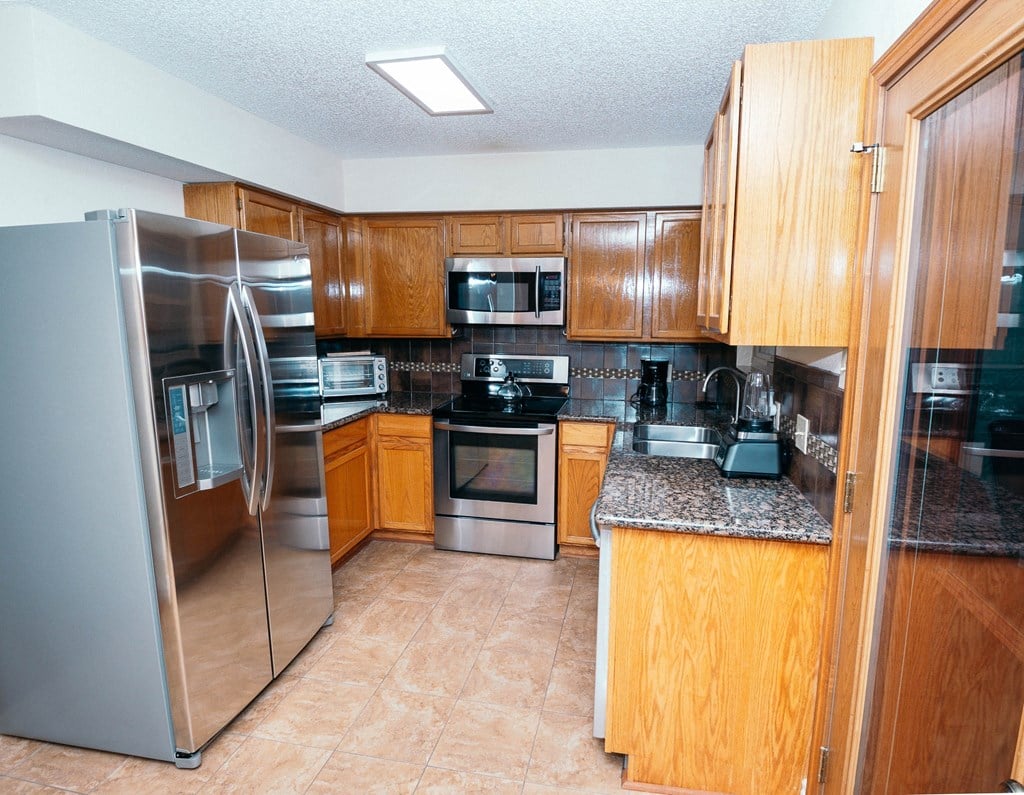 a kitchen with stainless steel appliances and wooden cabinets