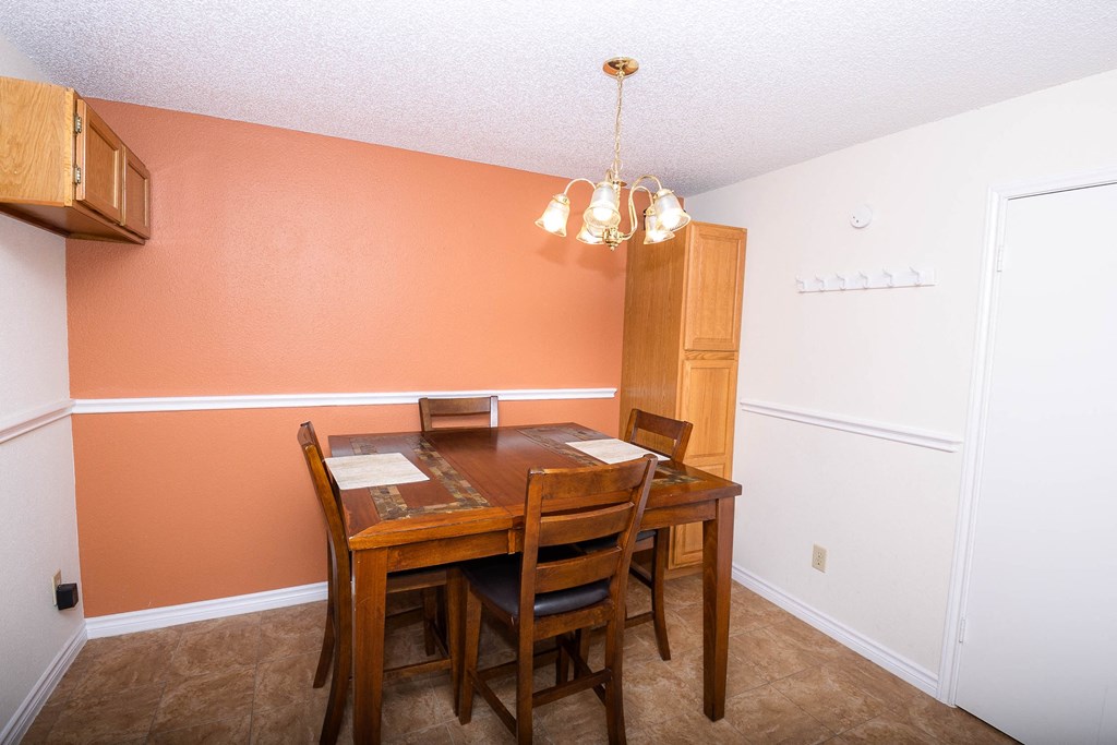 a dining room with a wooden table and chairs