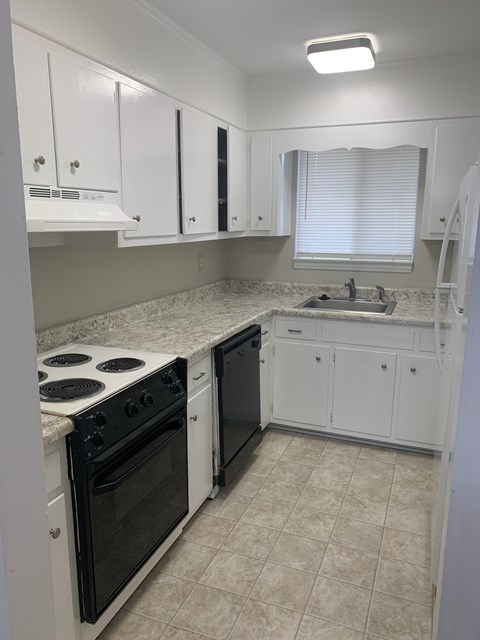 A kitchen with white cabinets and a black stove top oven.