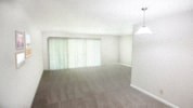 an empty living room with white walls and a window