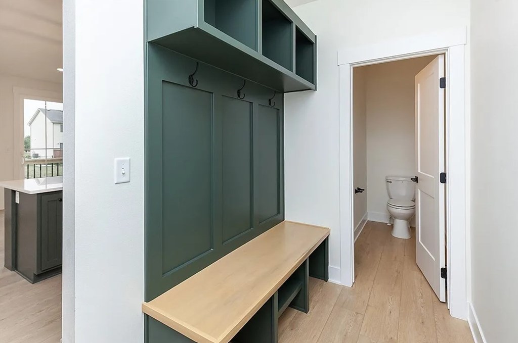 A kitchen with a bench and a toilet in the background.