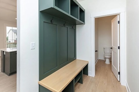 A kitchen with a bench and a toilet in the background.