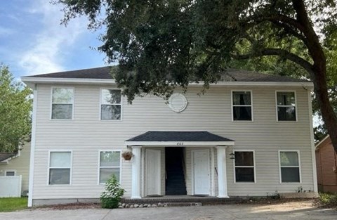 a white house with a tree in front of it