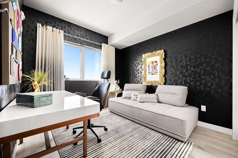 A black and white living room with a couch, chair, and a painting on the wall.