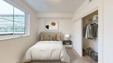 A bedroom with a large bed and a small nightstand with a lamp.