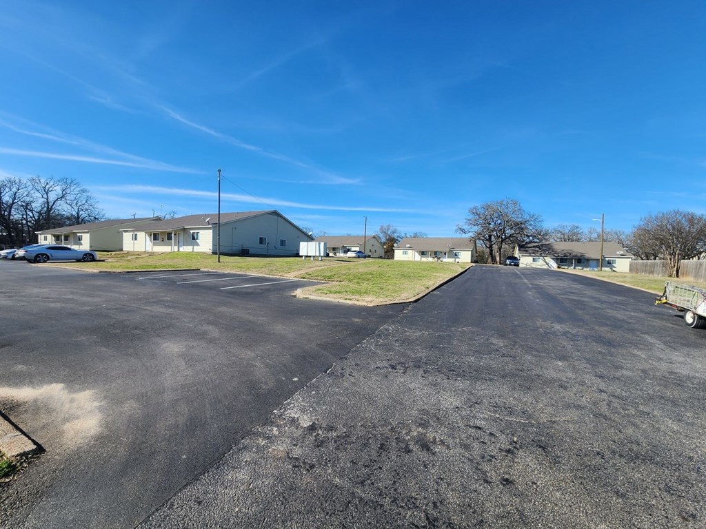 a street with houses in the background and a blue sky