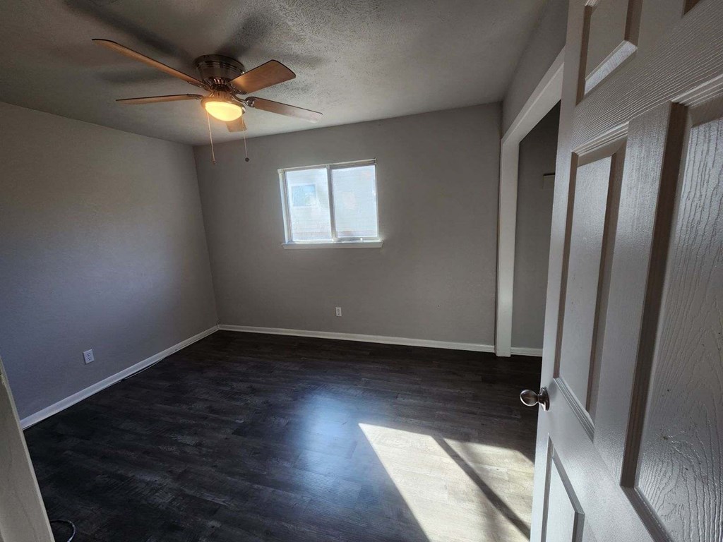 a empty room with a ceiling fan and a window