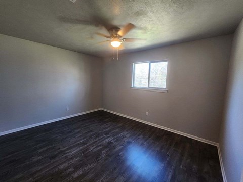 A room with a ceiling fan and a window.
