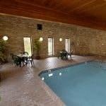 a swimming pool in a room with a table and chairs