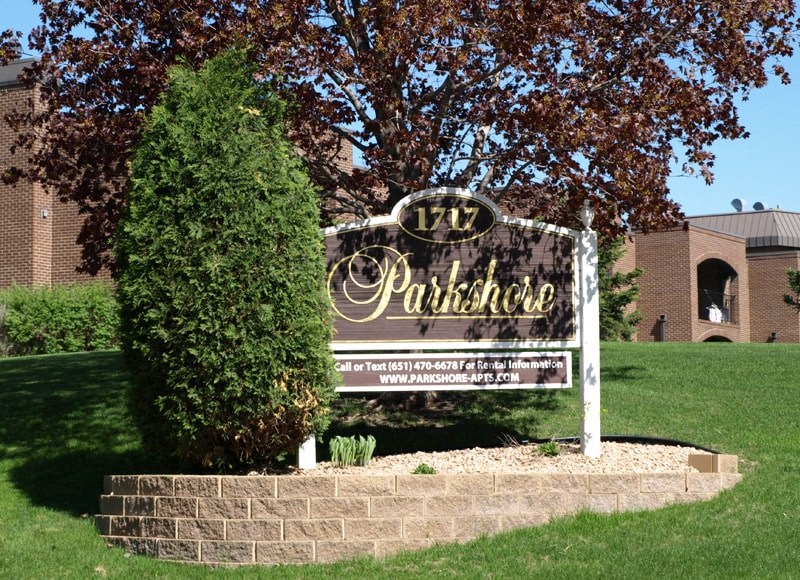 a sign in front of a building with a tree