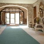 a large room with a green rug and doors