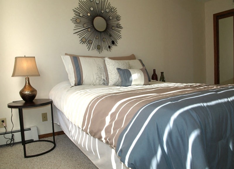 a bedroom with a bed and a mirror on the wall