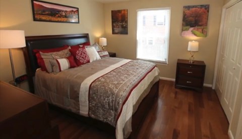 the master bedroom has a king size bed and hard wood floors