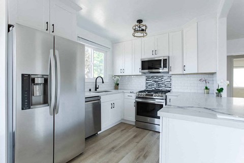 a kitchen with stainless steel appliances and white cabinets