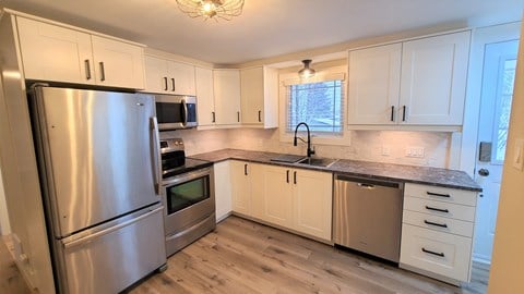 a kitchen with stainless steel appliances and white cabinets