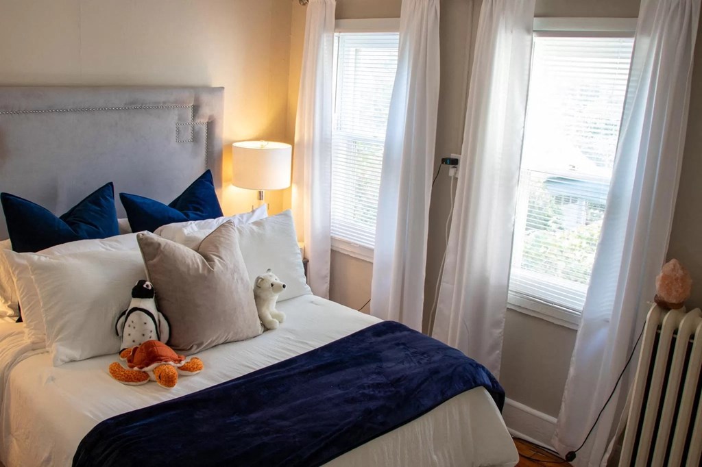 a bedroom with a bed with a stuffed animal on it