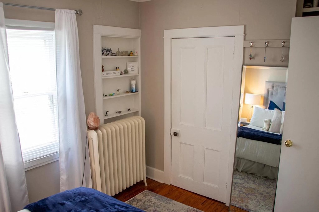 a bedroom with a bed and a closet and a white door