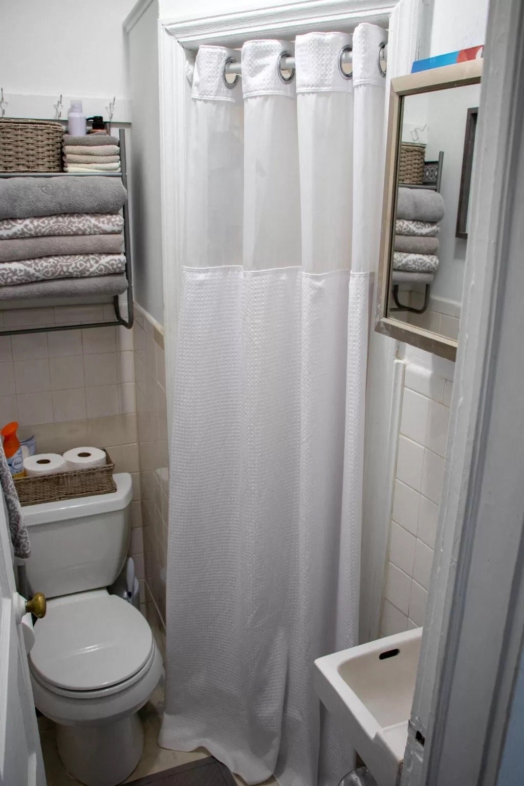 a bathroom with a toilet and a white shower curtain