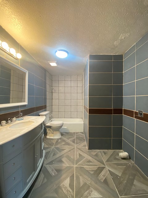 A bathroom with a toilet, sink, and shower.