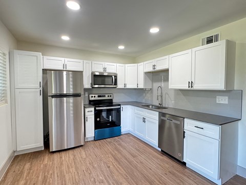 a kitchen with stainless steel appliances and white cabinets