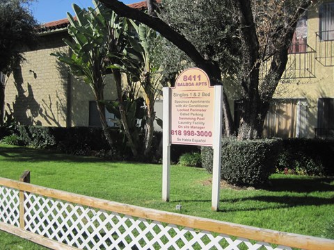 A sign for Baldwin Apartments stands in front of a building.