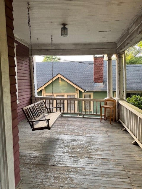 A porch with a bench and a table.