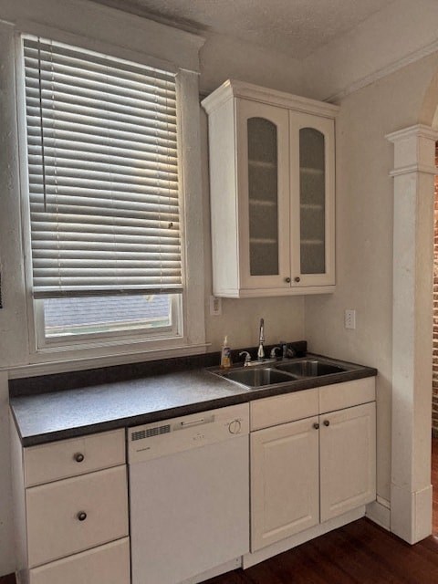 A kitchen with white cabinets and a black countertop.