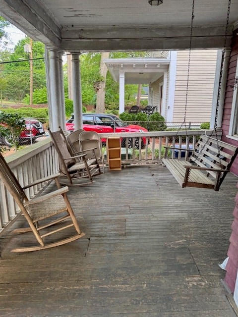 A porch with rocking chairs and a table.