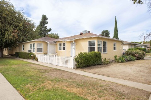A house with a white picket fence in front.
