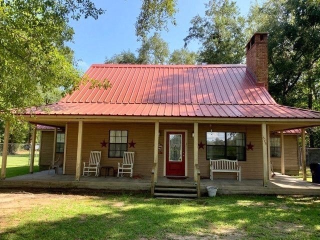 a small yellow house with a red metal roof