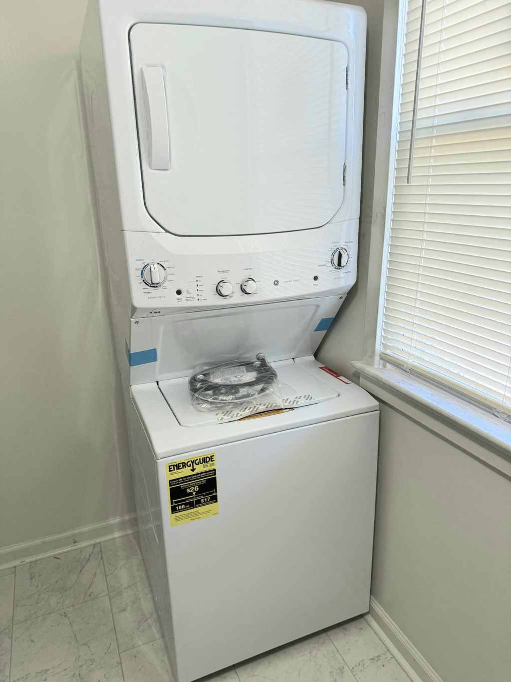 a dryer sitting on top of a washing machine in a bathroom