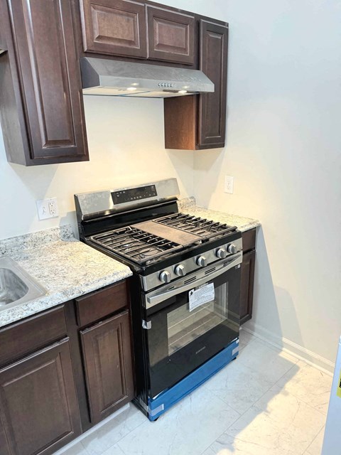 a kitchen with a stove and a microwave and a sink