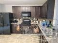 a kitchen with a counter and a refrigerator and a microwave