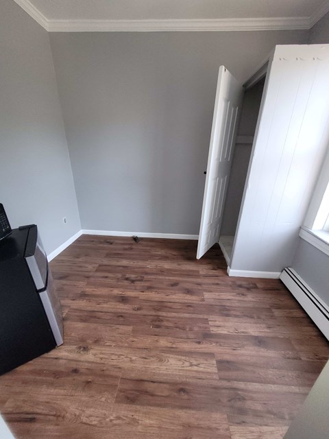 A room with a wooden floor and a white door.