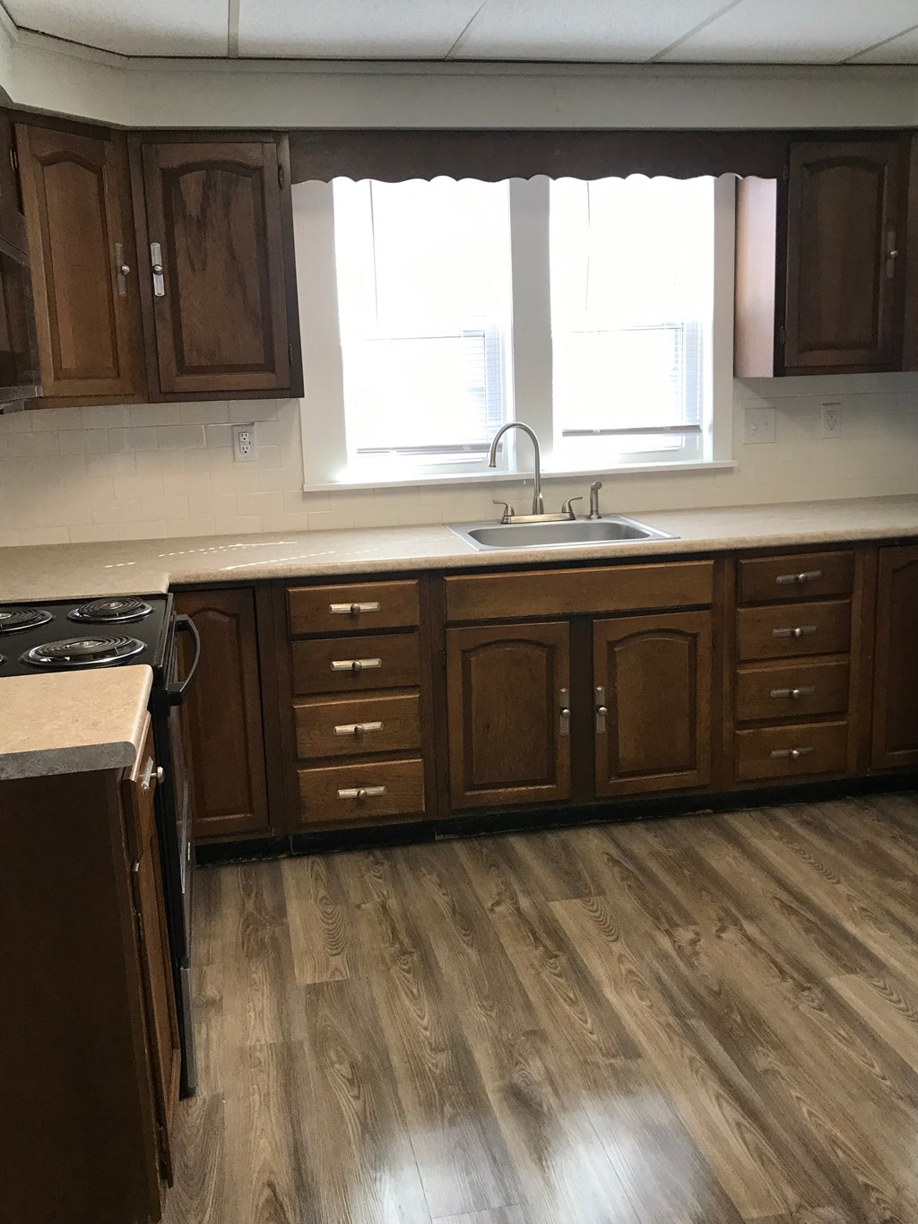 an empty kitchen with wooden floors and wooden cabinets