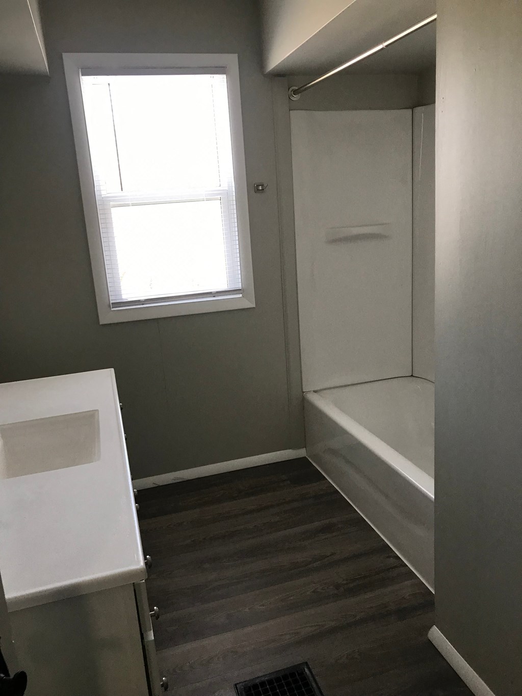 a small bathroom with a tub and a sink and a window