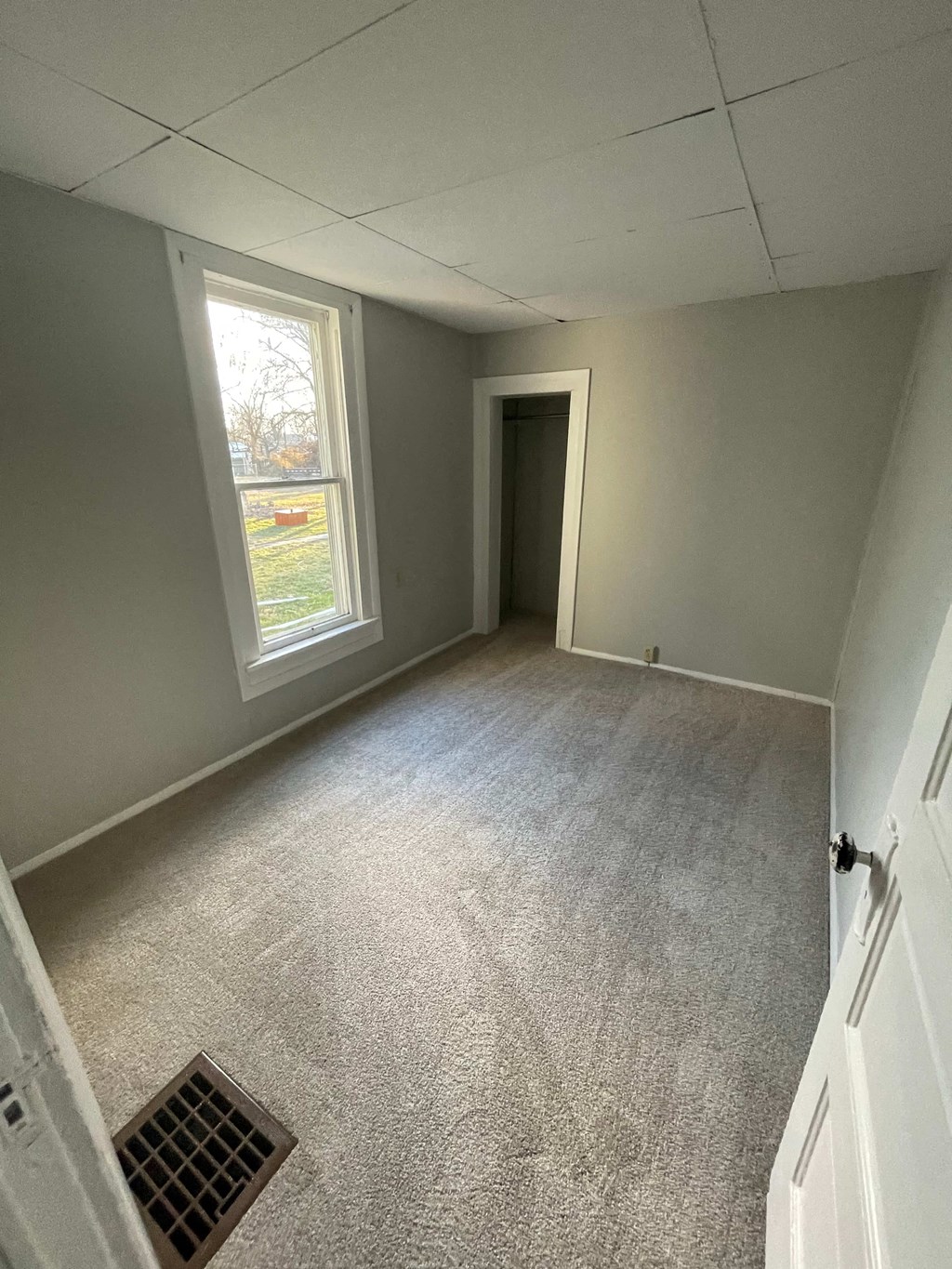 an empty room with a window and a door