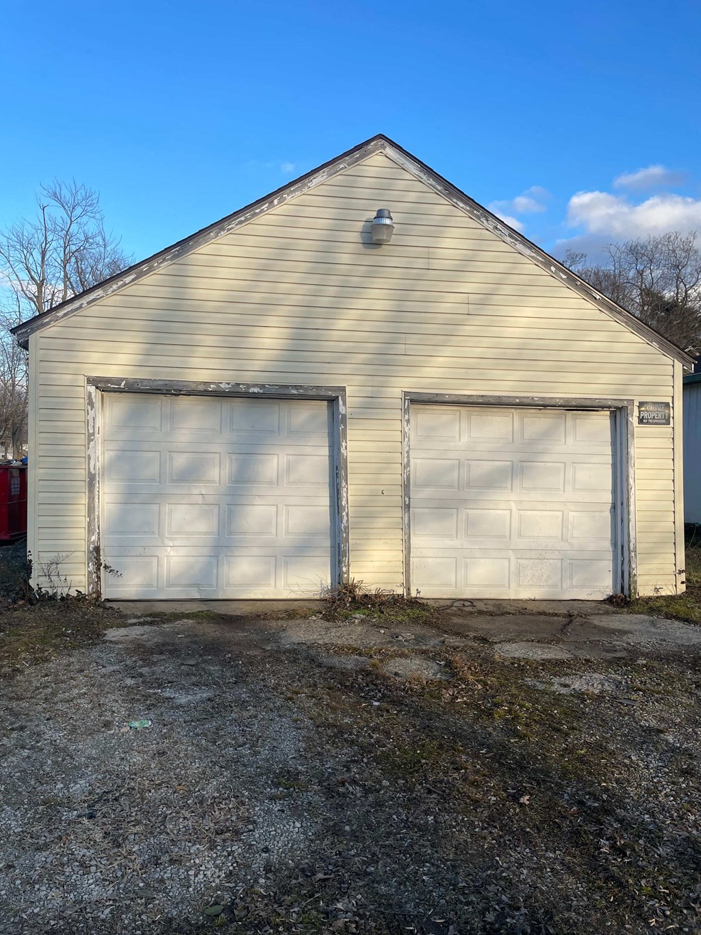 a white garage with two garage doors on the side of it