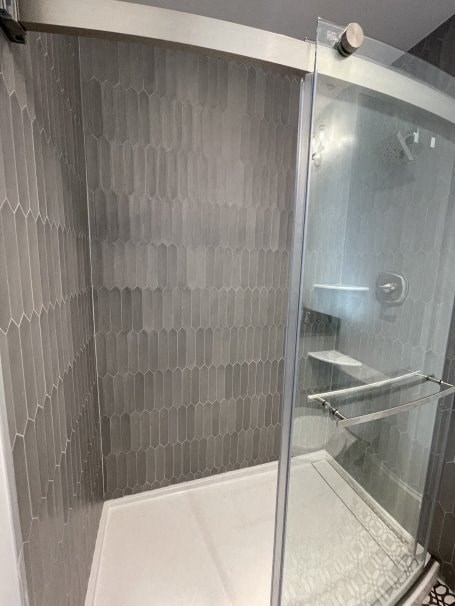 a bathroom with a shower with a glass door